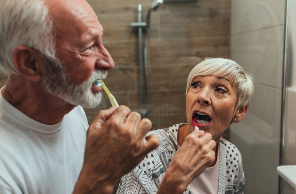 A senior couple brushing their teeth together. 