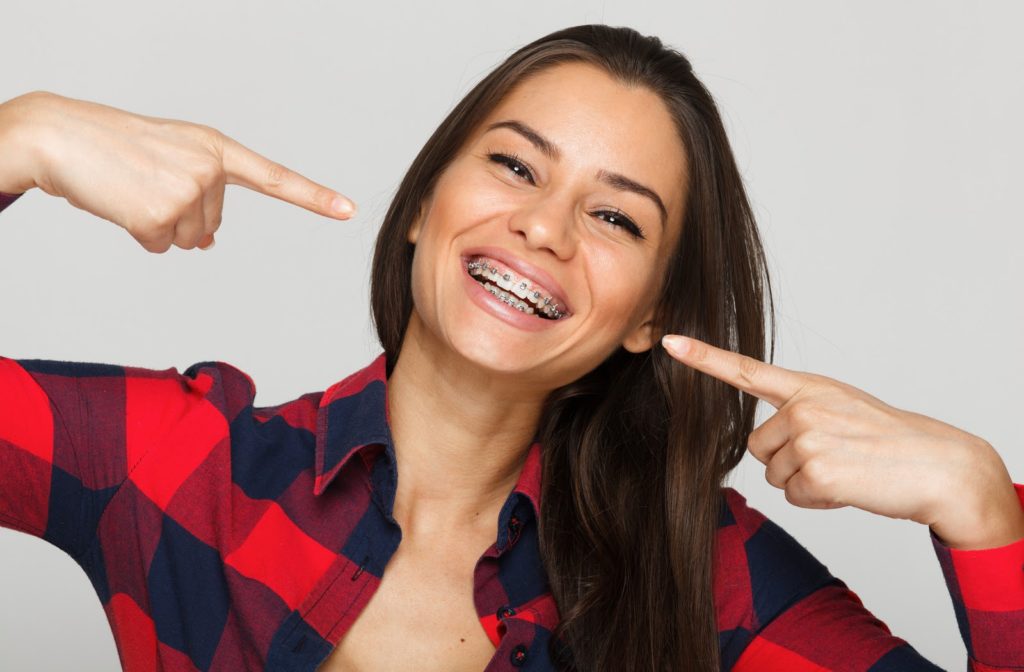 Young smiling woman pointing to her braces