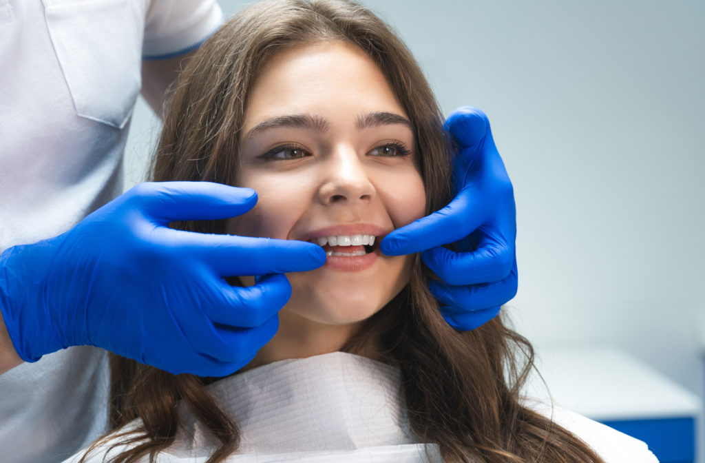 Happy women after dental cleaning smiling and looking at cleaned teeth