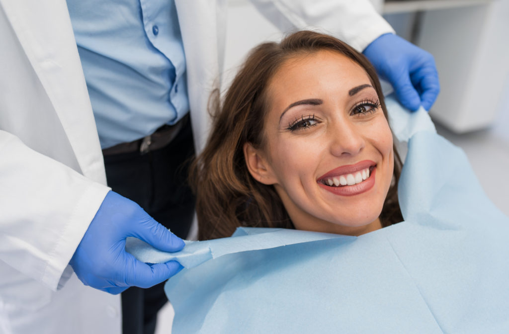 Happy patient sitting at chair of dentist ready for dental operation on teeth