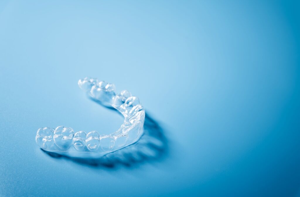 A close up of invisalign placed in a blue background