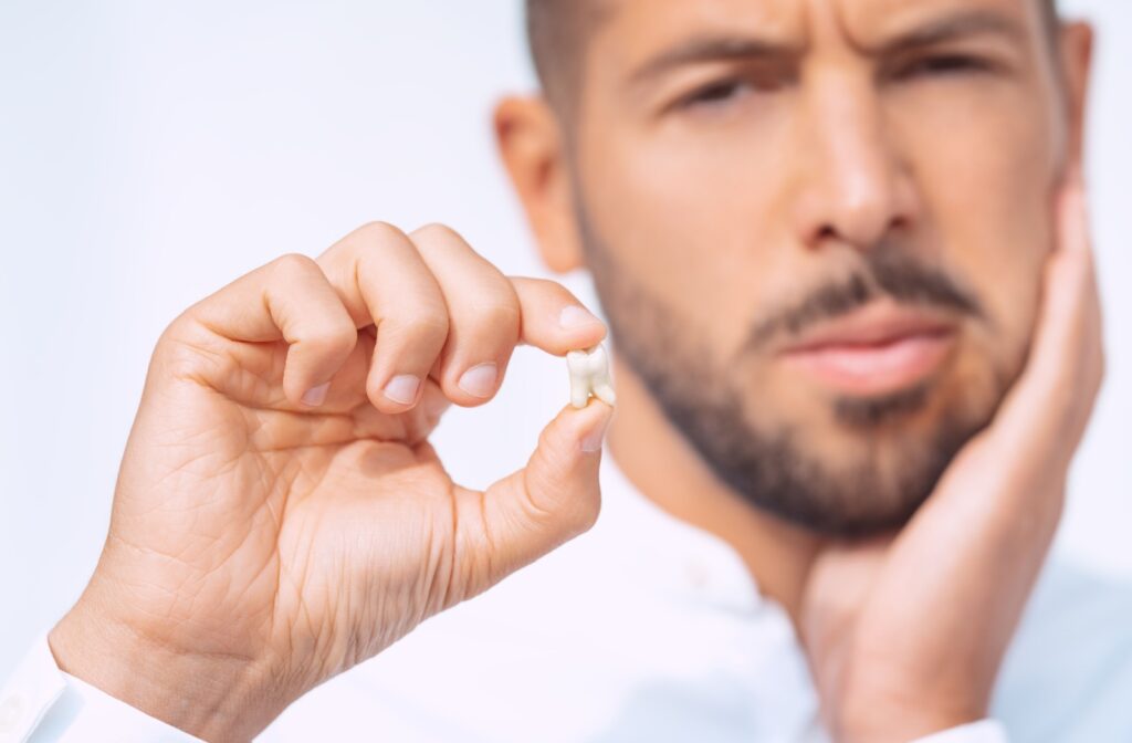 A person holding out their tooth after getting it extracted.