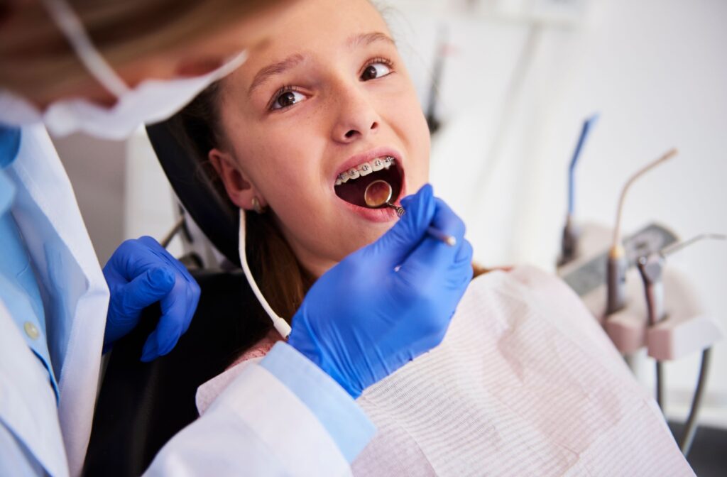 Orthodontist examining a patient's braces during a dental check-up.