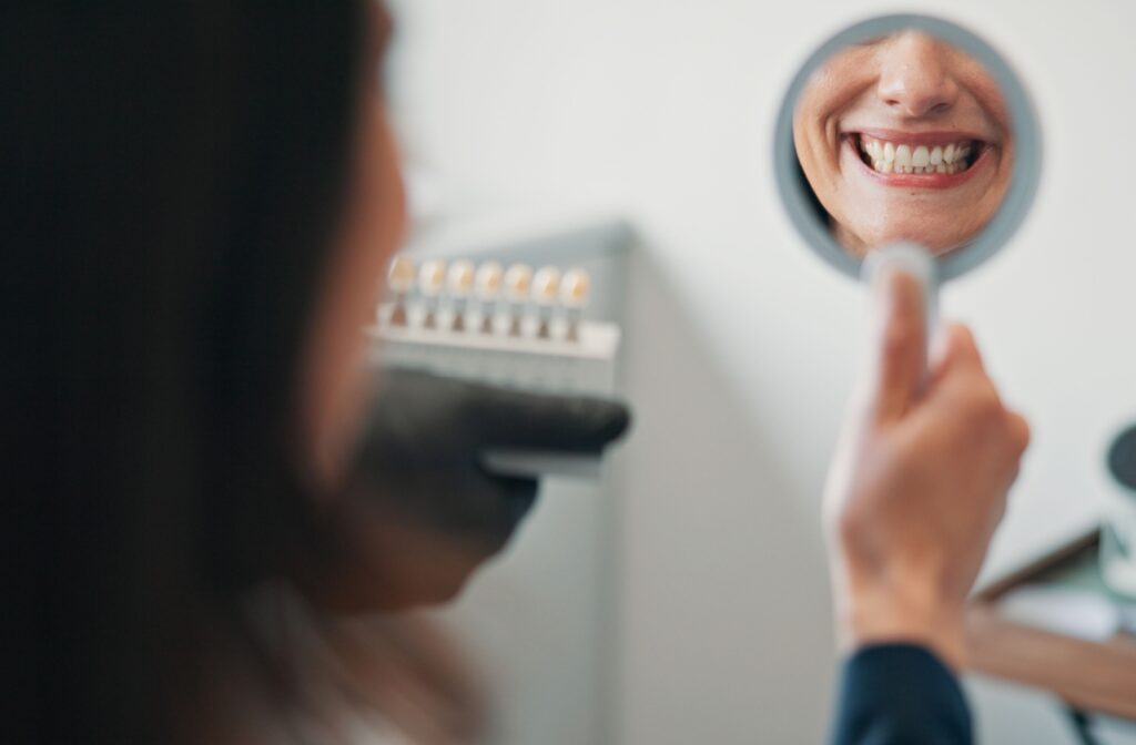 Person at a dental office looking in a mirror and smiling